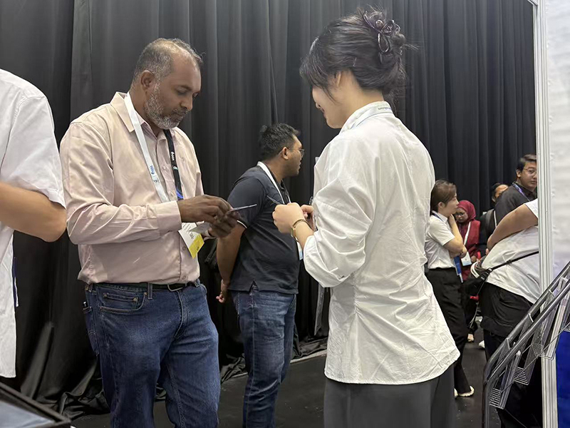 shenhai sales representative exchanging business cards with client at oga 2026